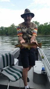 A man is standing on a boat holding a fish.