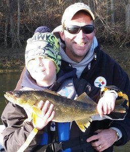 A man wearing a hawks hat is holding a fish