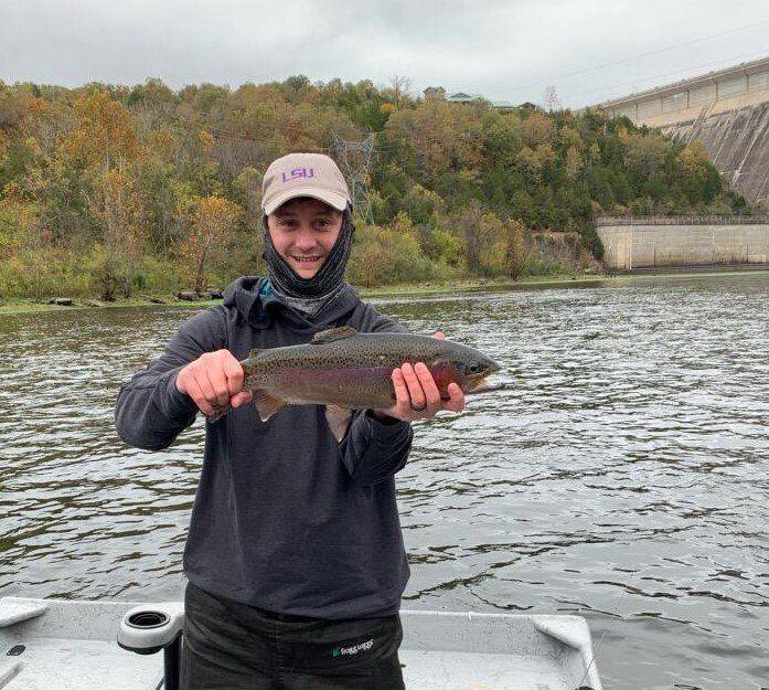 A man is standing on a boat holding a fish in his hands.