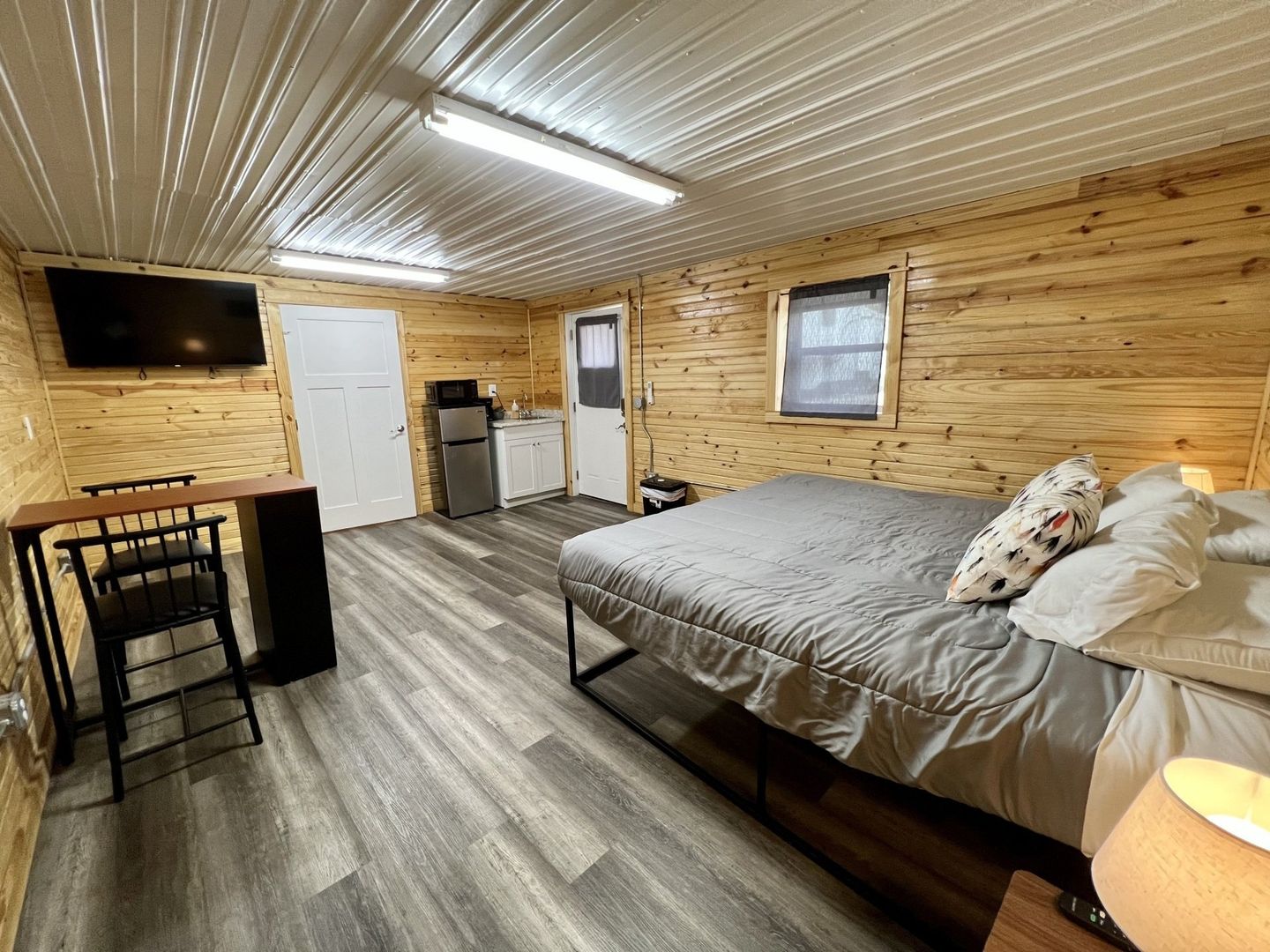 campers cabin with mini fridge, microwave, vanity, desk, and bed at copper johns resort