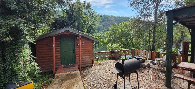 log cabin on white river with seating around firepit copper johns resort cabin 1