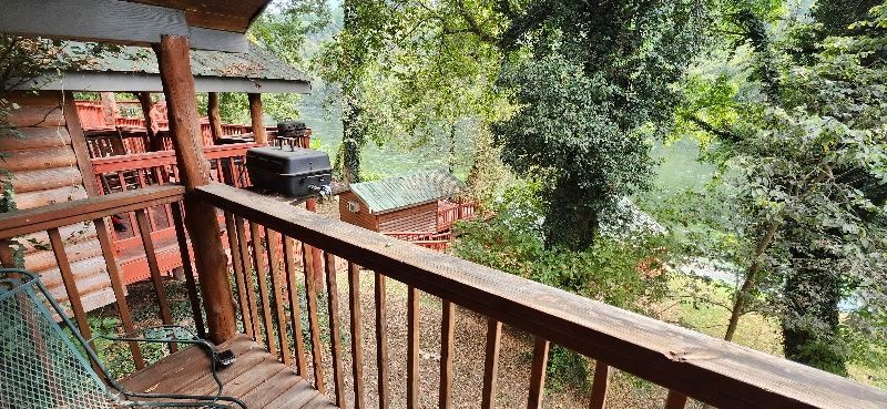 covered patio with firewood, smoker, and picnic table on white river at copper johns resort