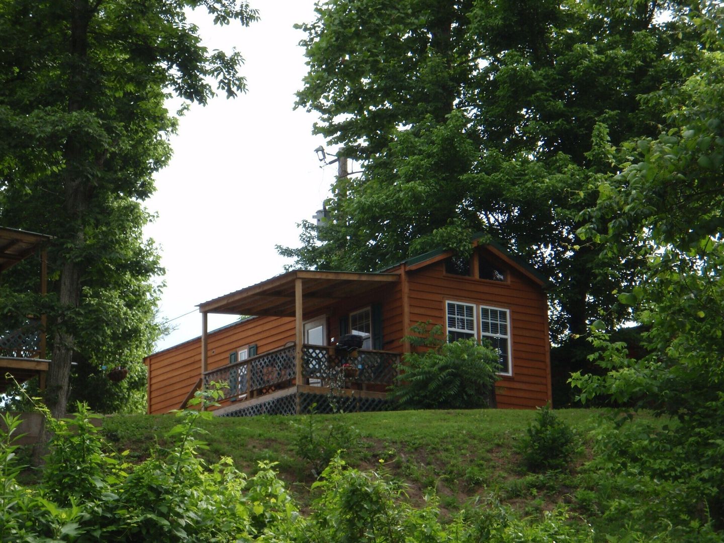 A small cabin sits on top of a hill surrounded by trees at copper johns resort