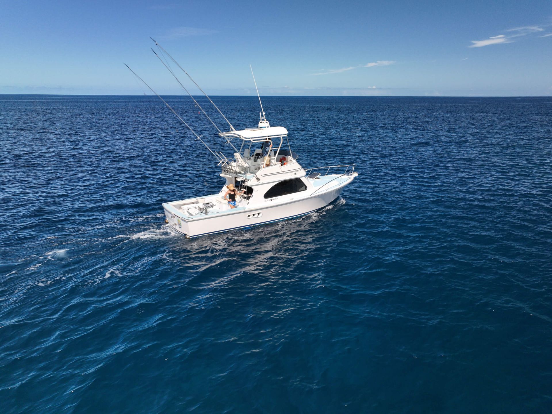 A white boat is floating on top of a large body of water.