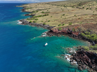 An aerial view of a boat in the middle of a body of water.