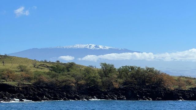 A mountain covered in snow is visible behind a body of water.