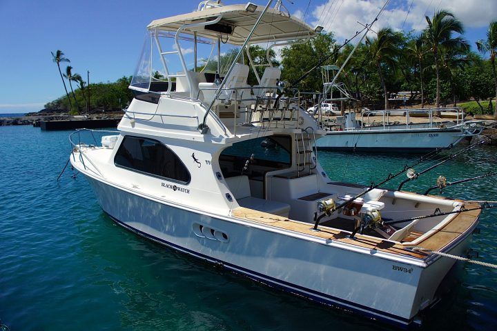 A white boat is floating on top of a body of water.