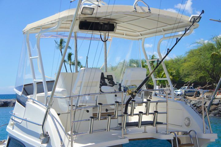 A boat with a fishing rod attached to it is docked in the water.