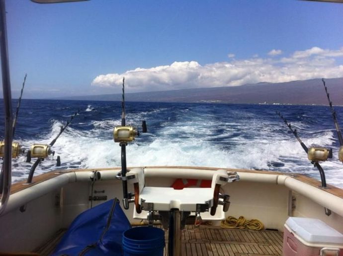 A boat filled with fishing rods and a pink cooler