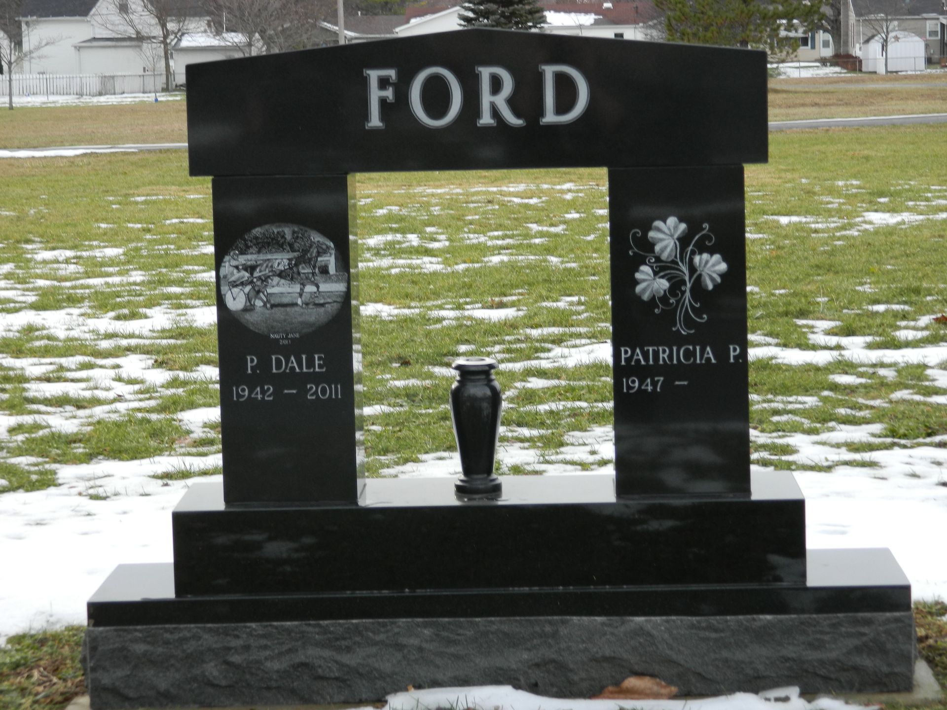 Black Ford gravestone with engraved photos in a snowy cemetery