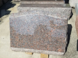 Granite block steps with a polished reddish-speckled face outdoors