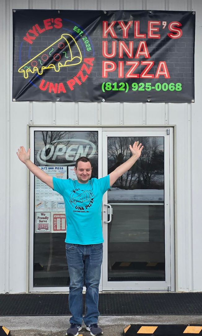 A man is standing in front of kyle 's una pizza
