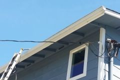 A ladder is sitting on the side of a house next to a window.
