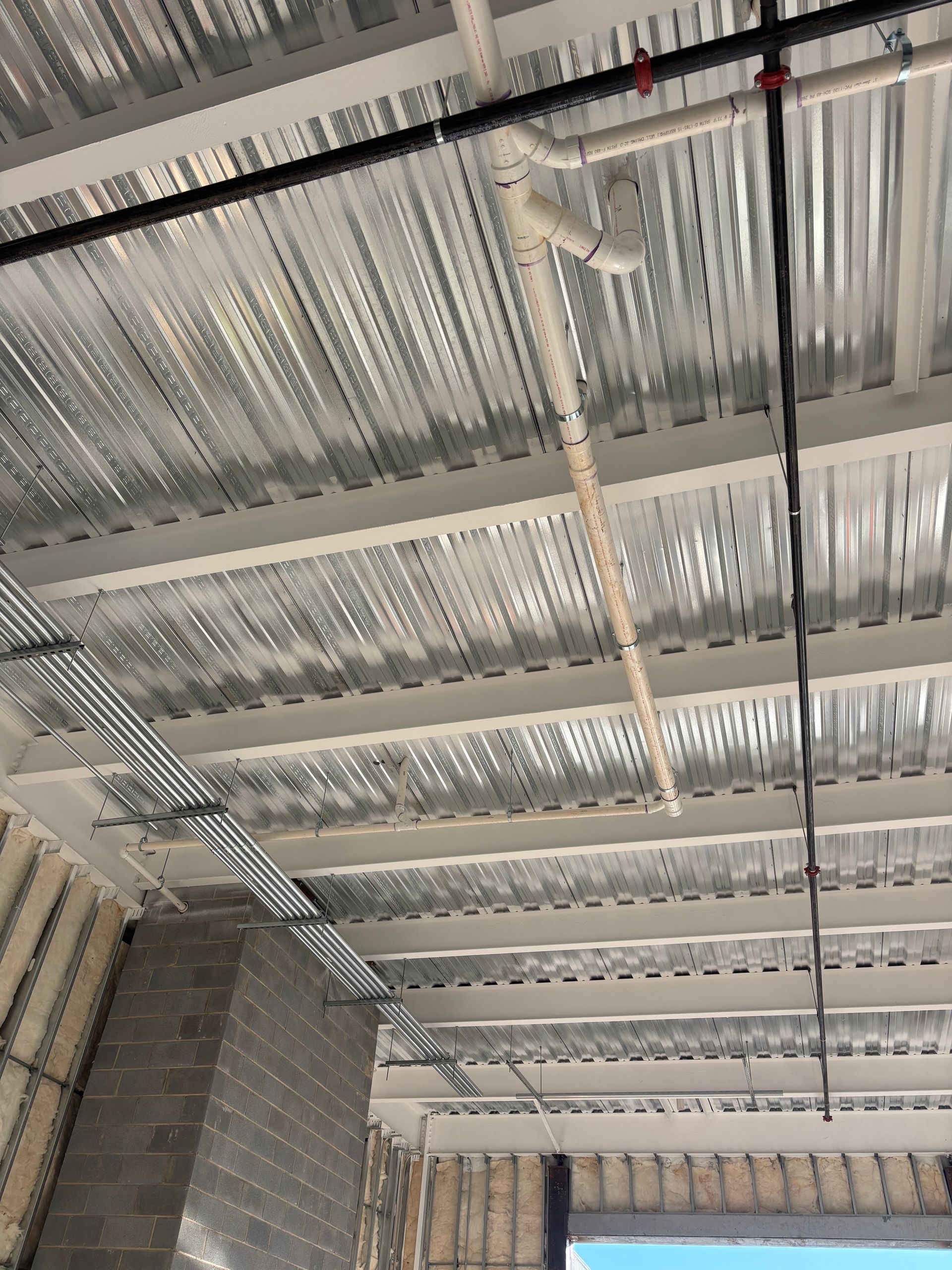 Metal roof with pipes and electrical conduit.