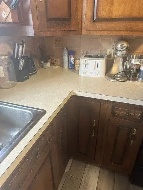 Kitchen countertop with sink, cabinets, and appliances including a mixer and toaster