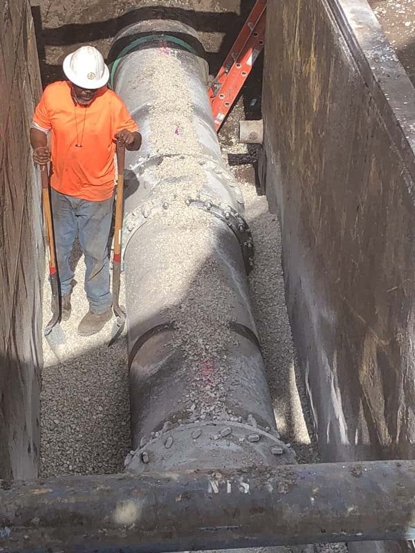 two workers attaching large PVC pipes together
