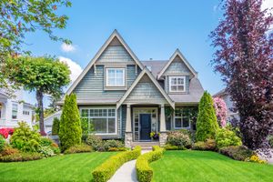 A large house with a lush green lawn and trees in front of it.