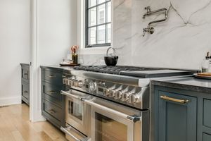 A kitchen with a stove top oven and a window.