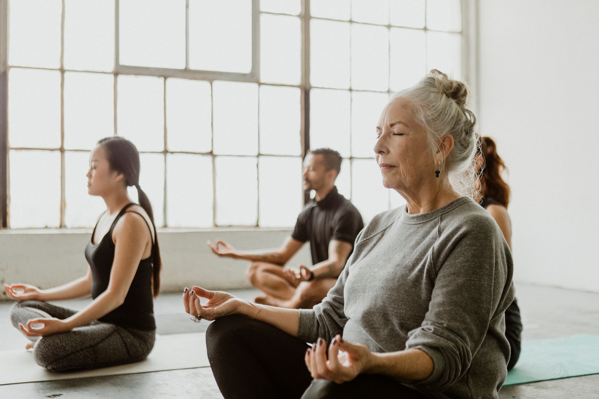  People sitting and meditating during a yoga class