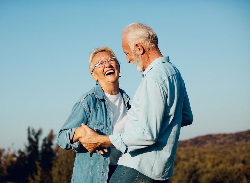 Older couple laughing and holding each other