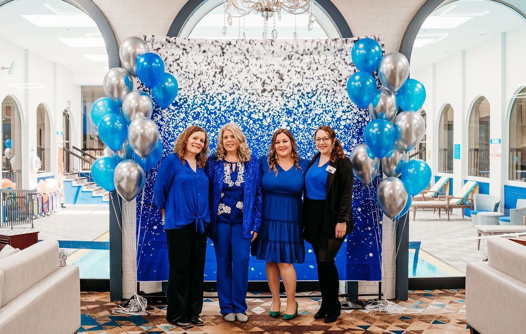 Silverfern staff members posing in front of a backdrop