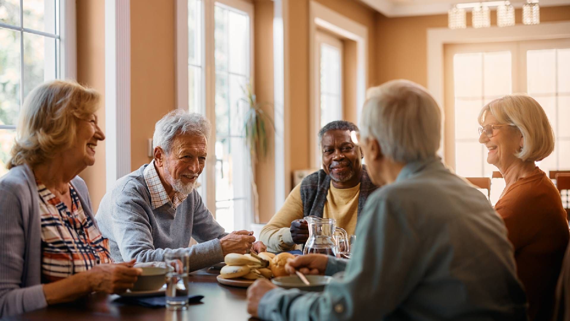 Five 55+ people share a meal and laughter in their community near Cincinnati, Ohio (OH)