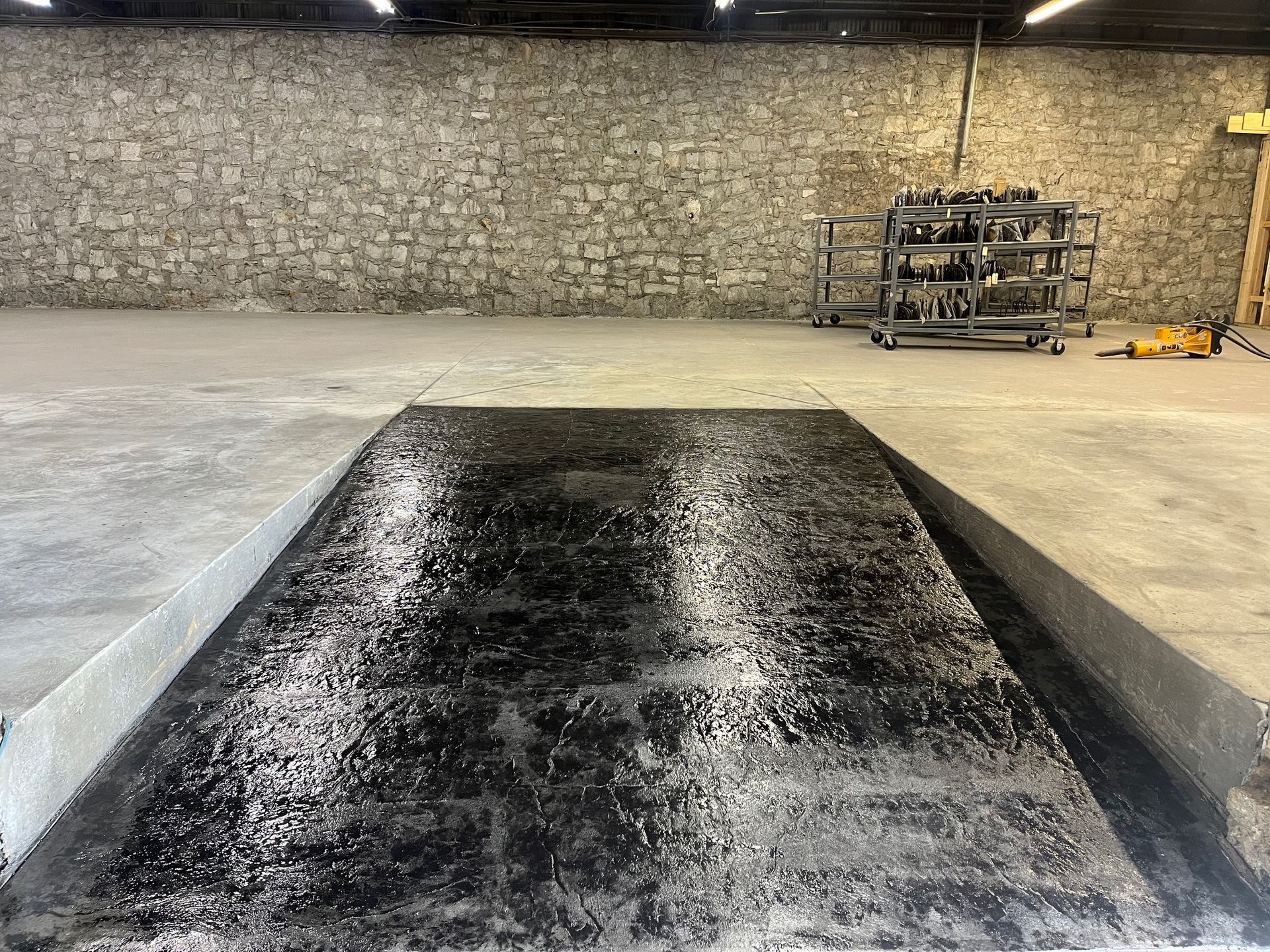 A warehouse with a concrete floor and a brick wall.