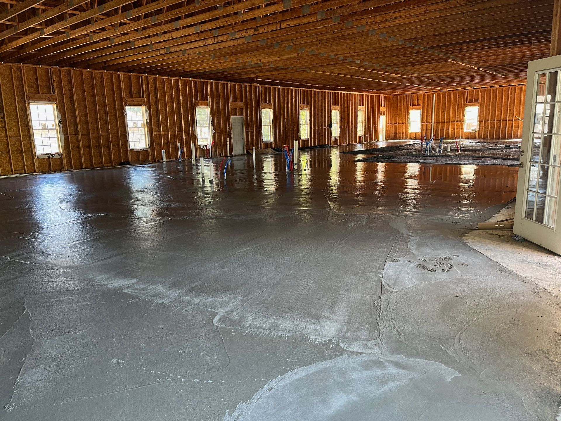 A large room with a concrete floor and wooden walls