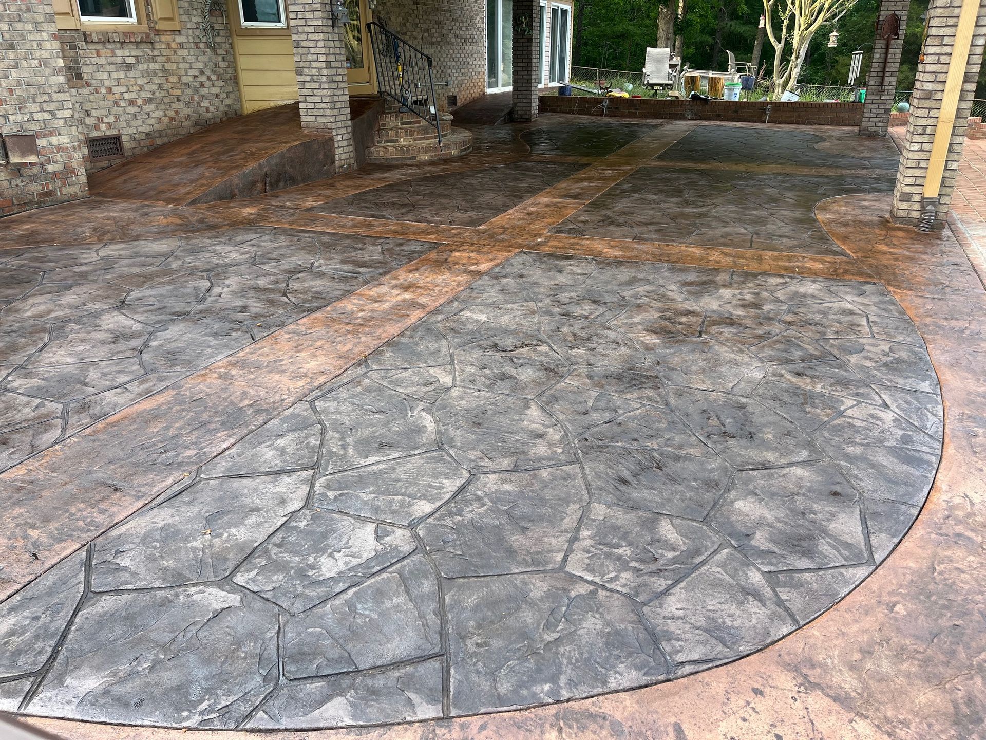 A concrete patio with a circular design in front of a house.