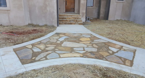 A stone walkway is leading to the front door of a house.