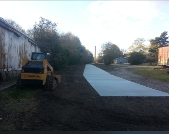 A yellow tractor is parked on the side of a road