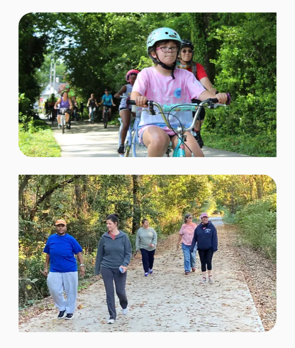A group of people are riding bikes and walking down a path