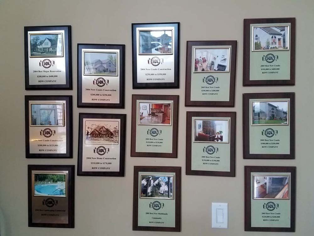 Wall displays framed plaques with photos and text, possibly for an award or recognition in a house.