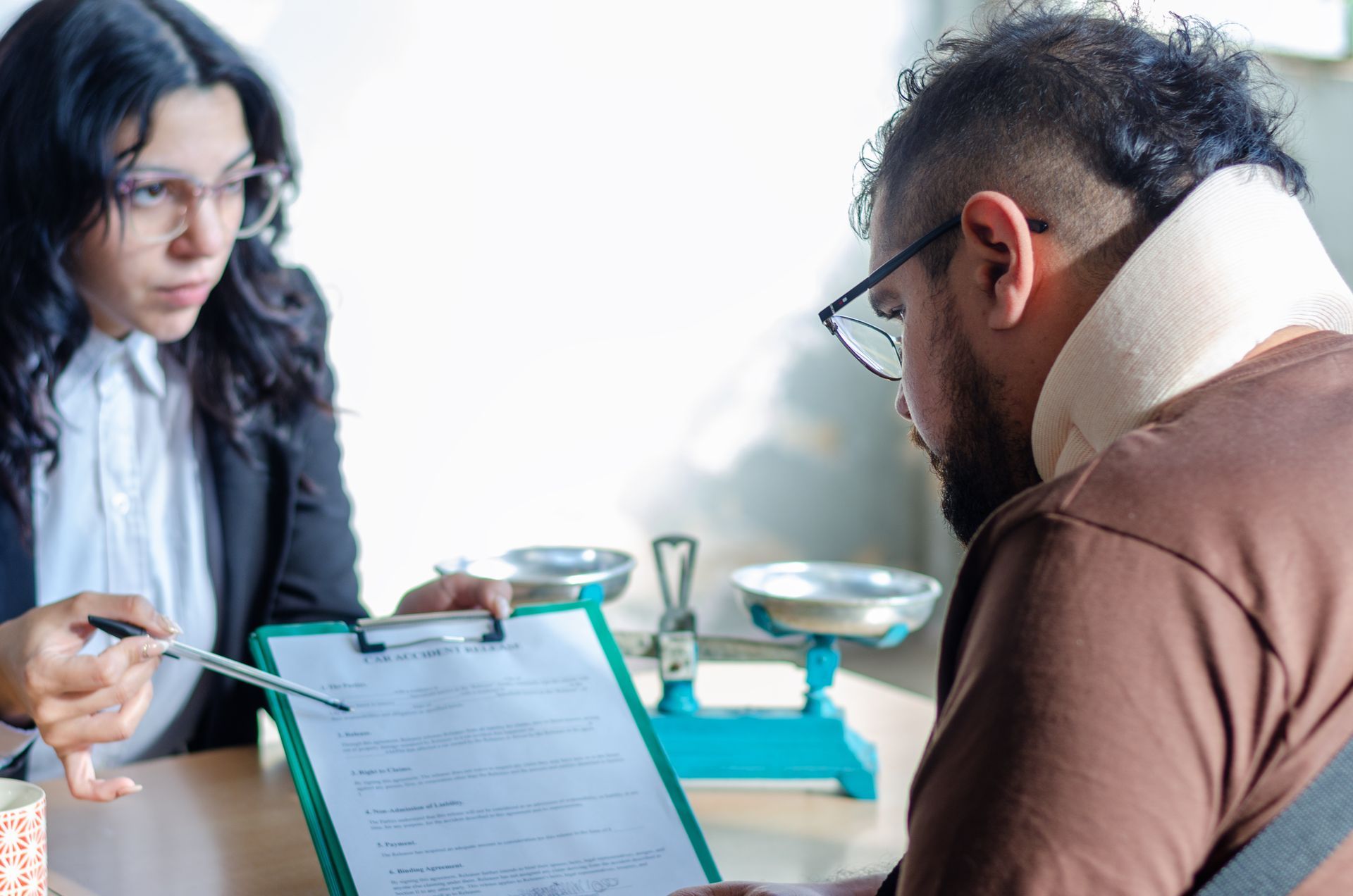 A legal consultation at a desk as the client reviews documents A legal consultation at a desk as the client reviews documents