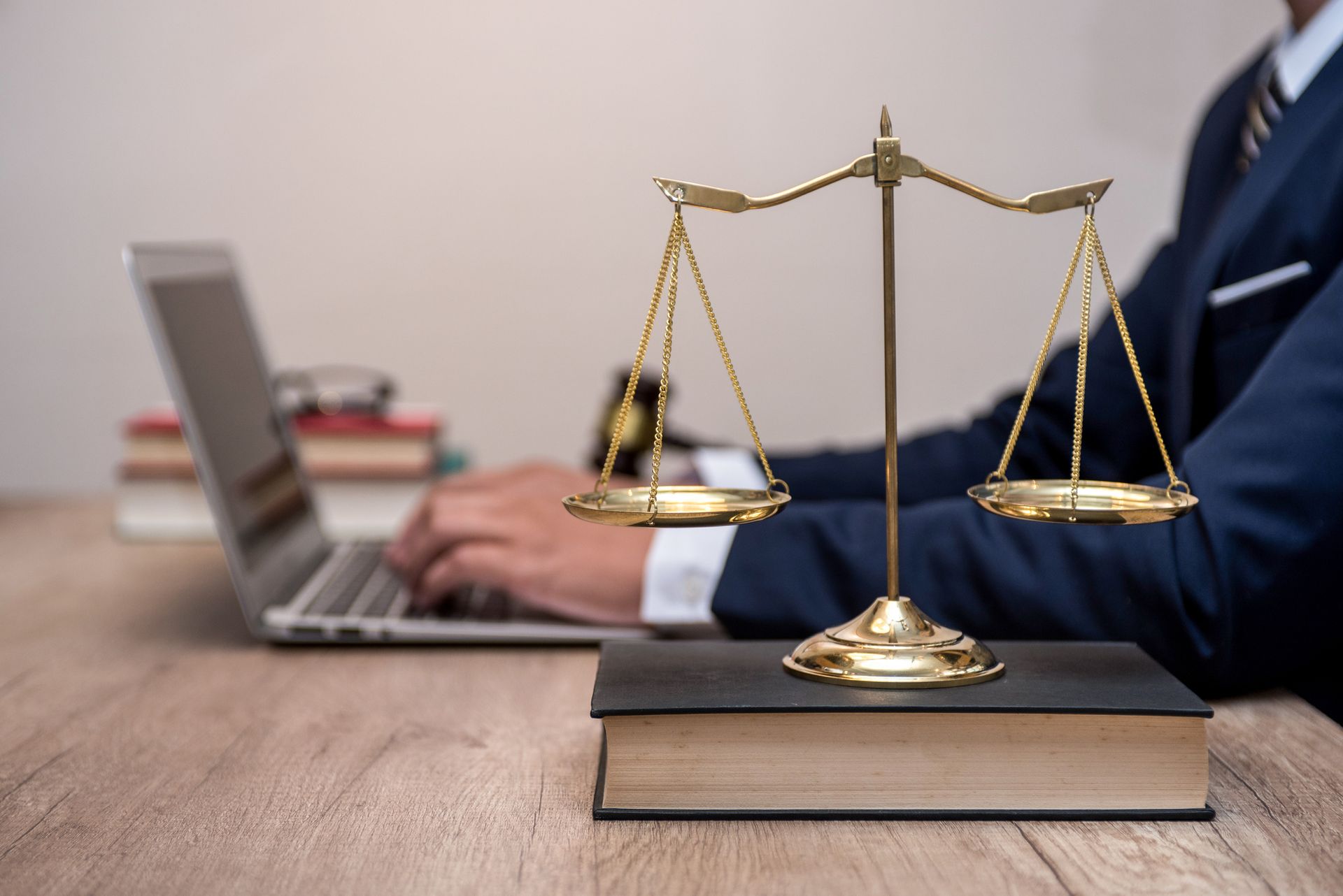 Lawyer at Schulze, Cox & Will Law Office in Delaware, OH, working on a laptop with a justice scale. 