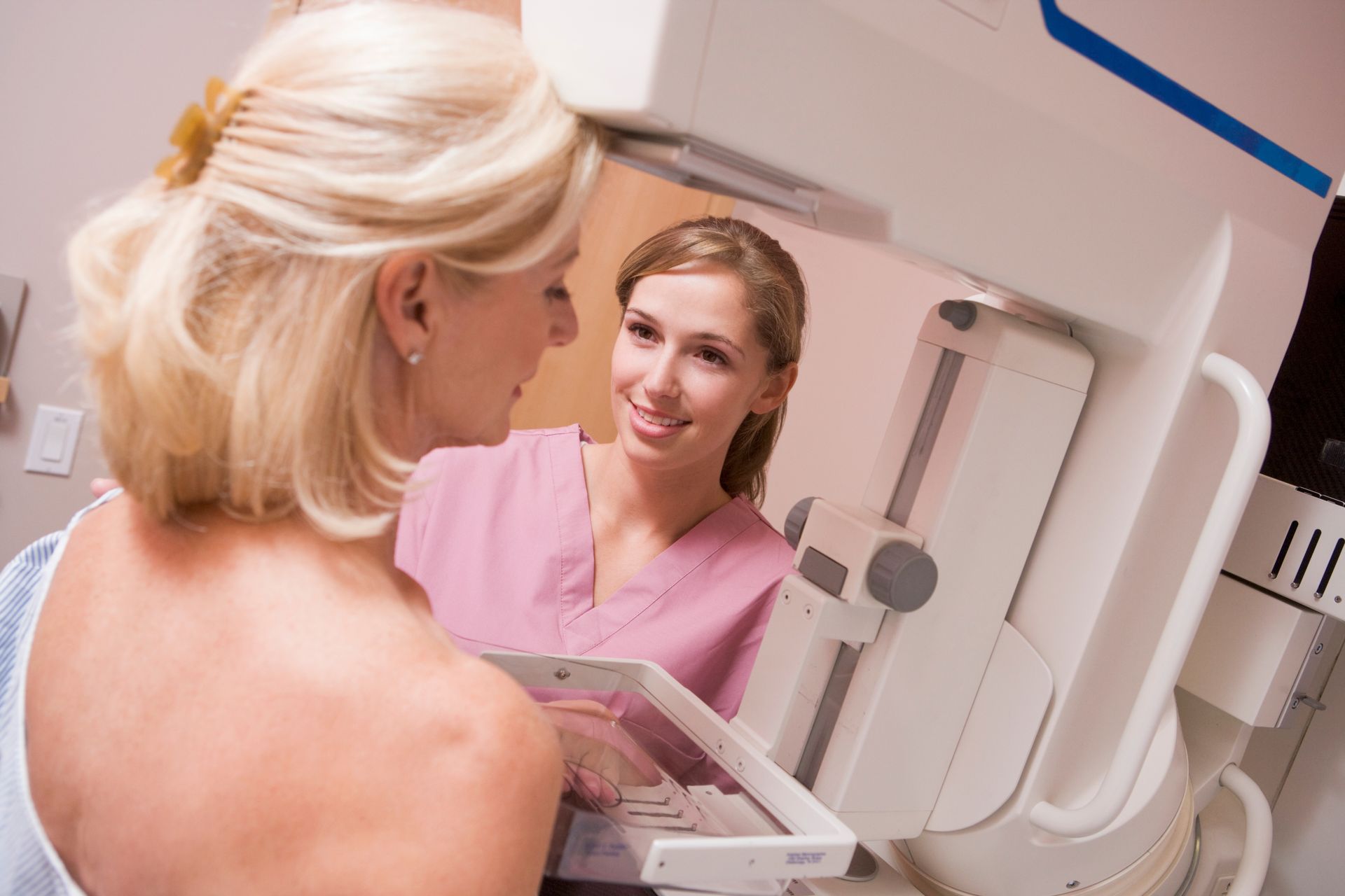 a woman is getting a mammogram from a nurse .