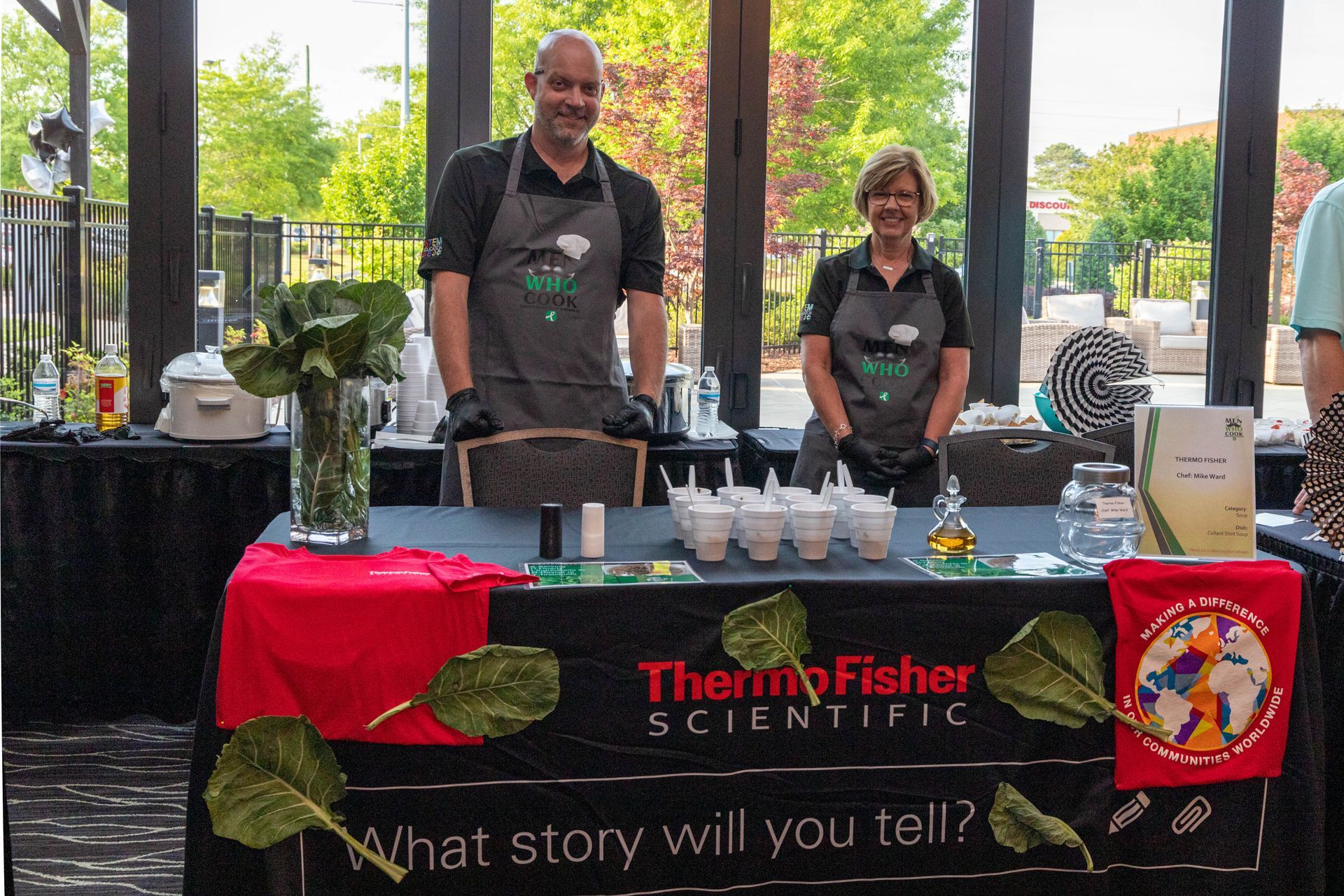 a man and a woman are standing behind a table that says thermo fisher scientific