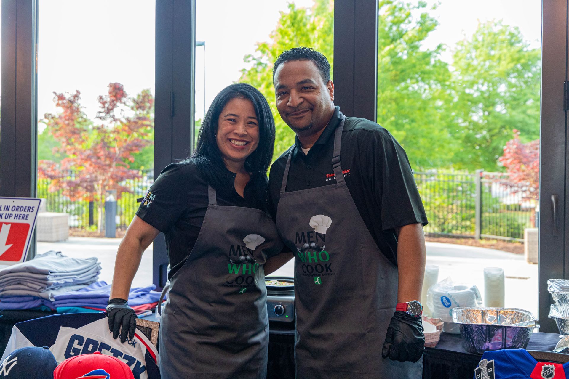 a man and a woman wearing aprons are posing for a picture .