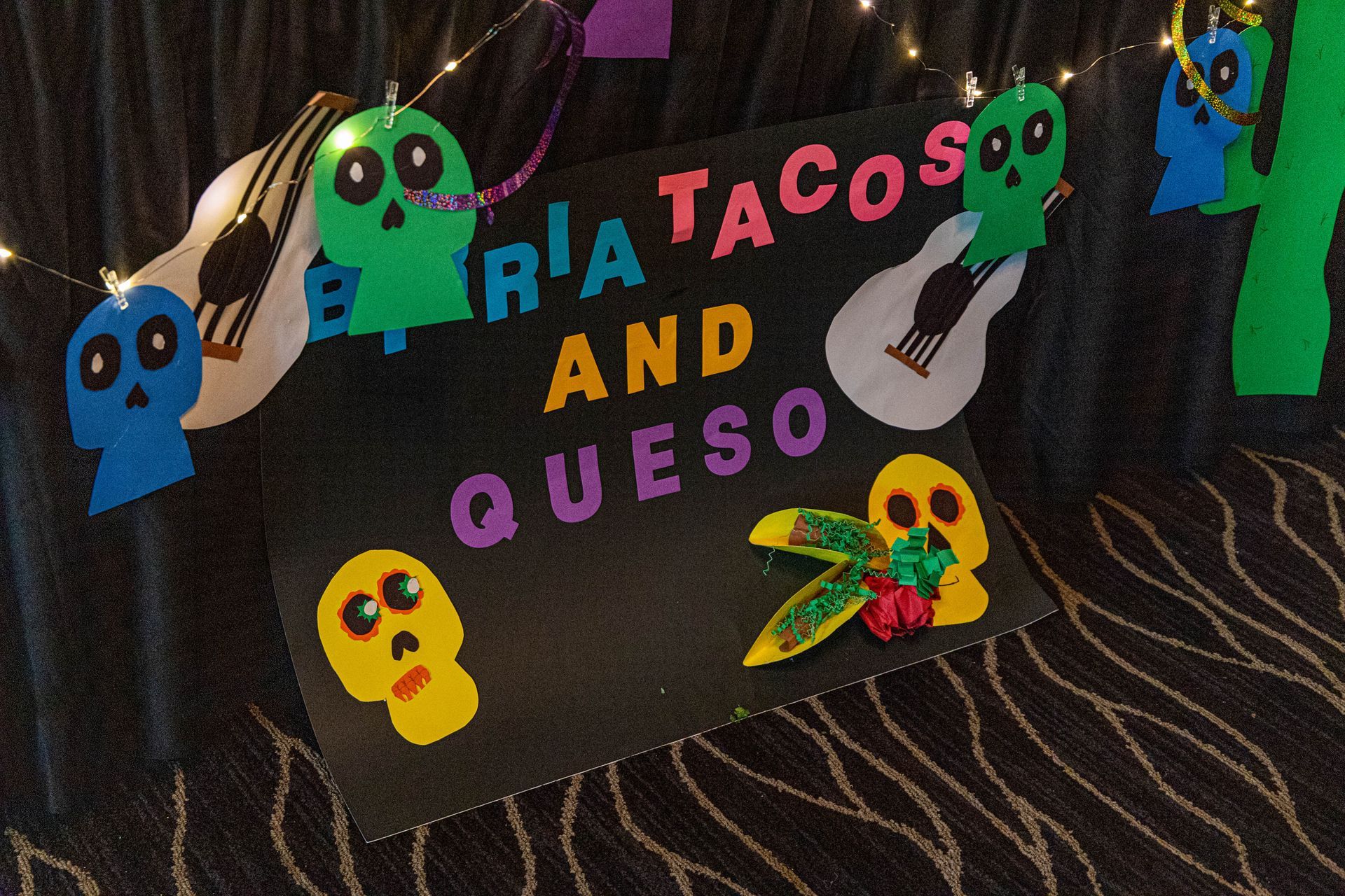 sign with skulls and birria tacos and queso on it