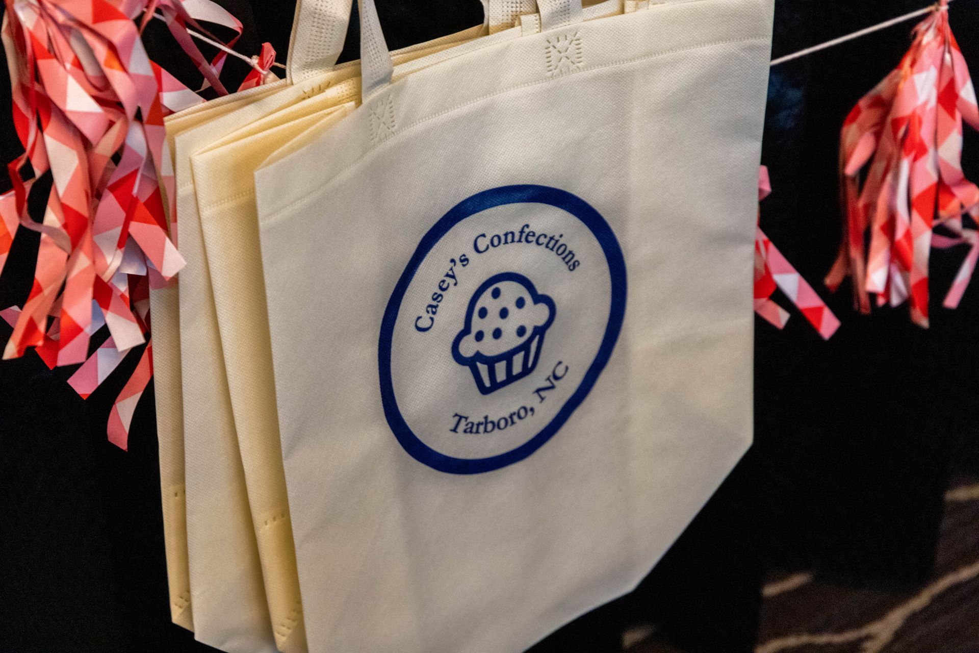 a white tote bag that says casey 's candies on it