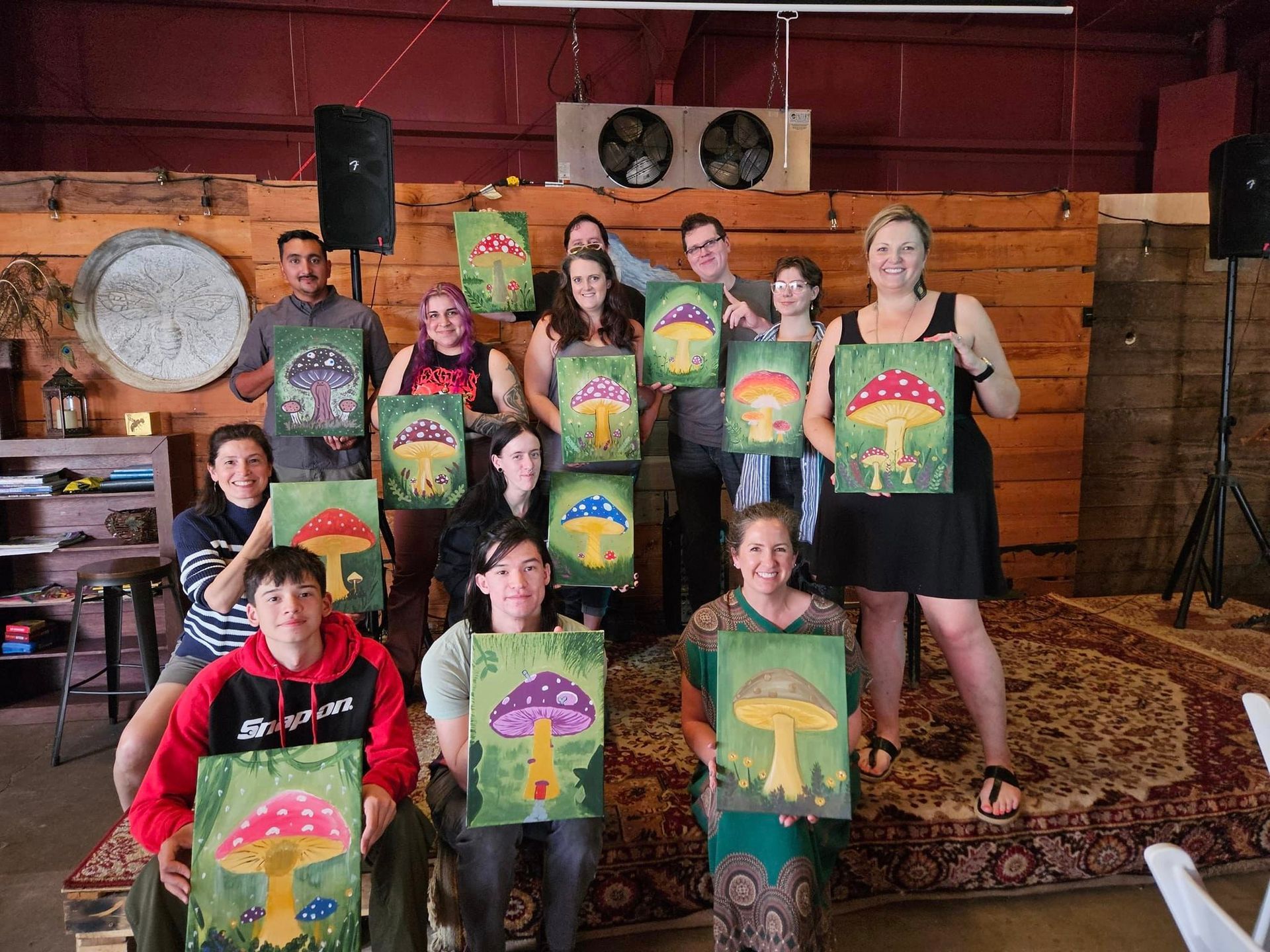 Twelve proud folks showing off their different takes on the Forest Mushroom theme Paint Party from July 2024.