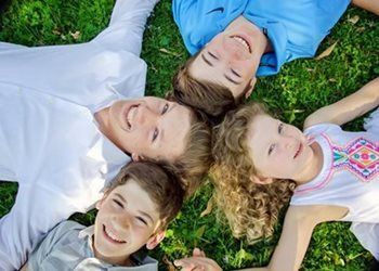 Group of children lying in the green grass