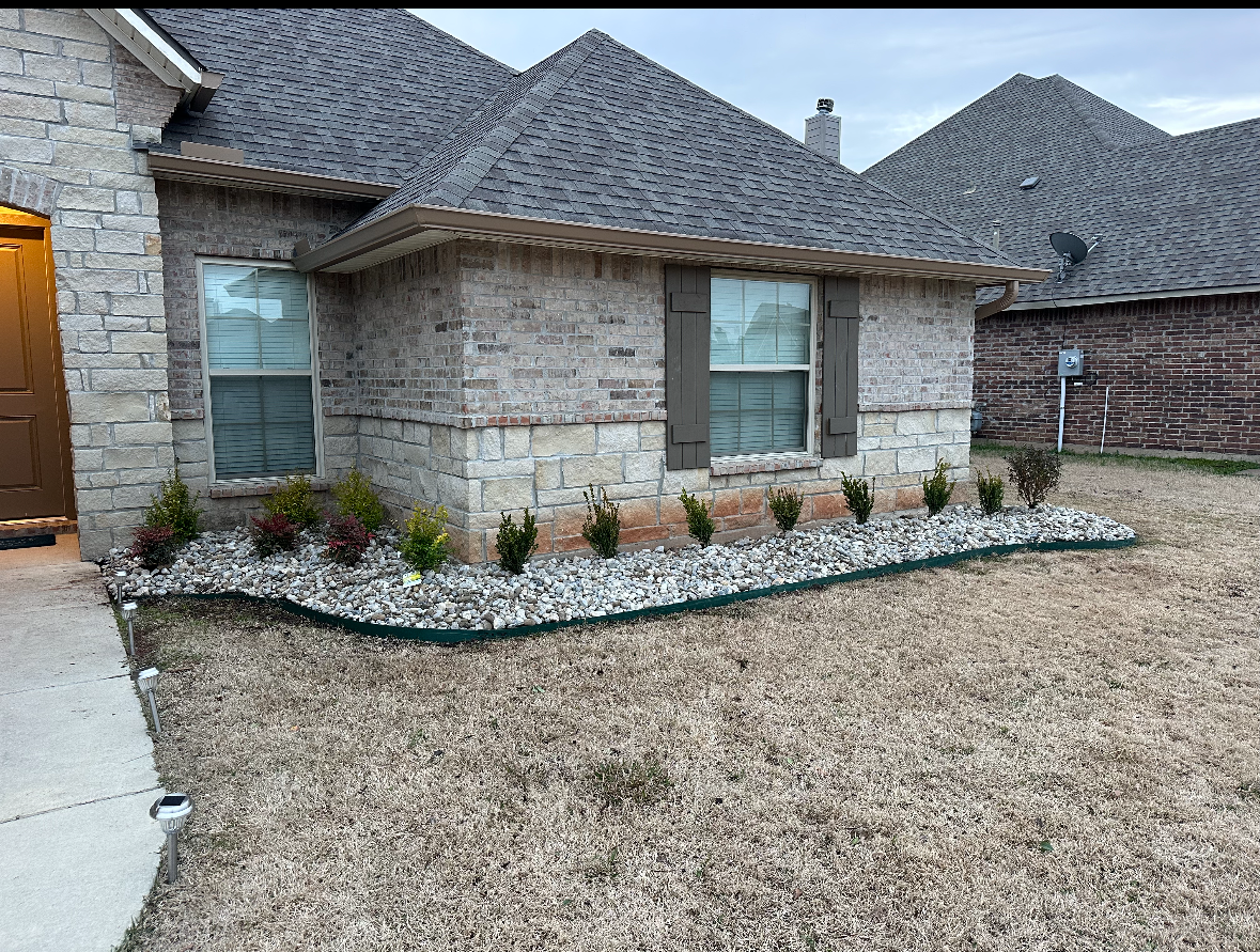A brick house with a gravel garden in front of it.