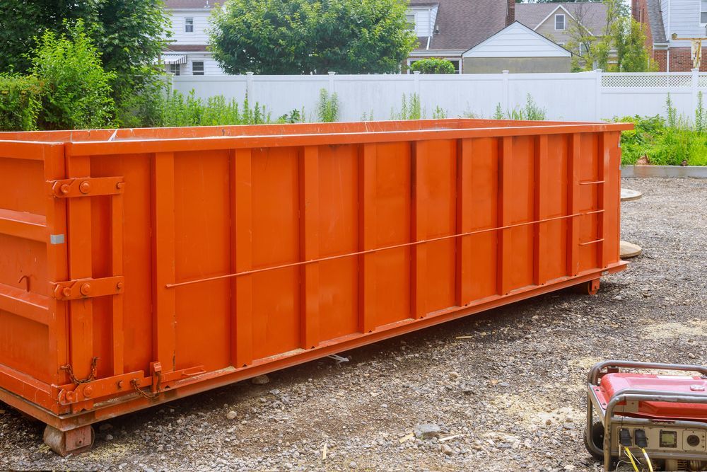 A blue dumpster is filled with branches and leaves.