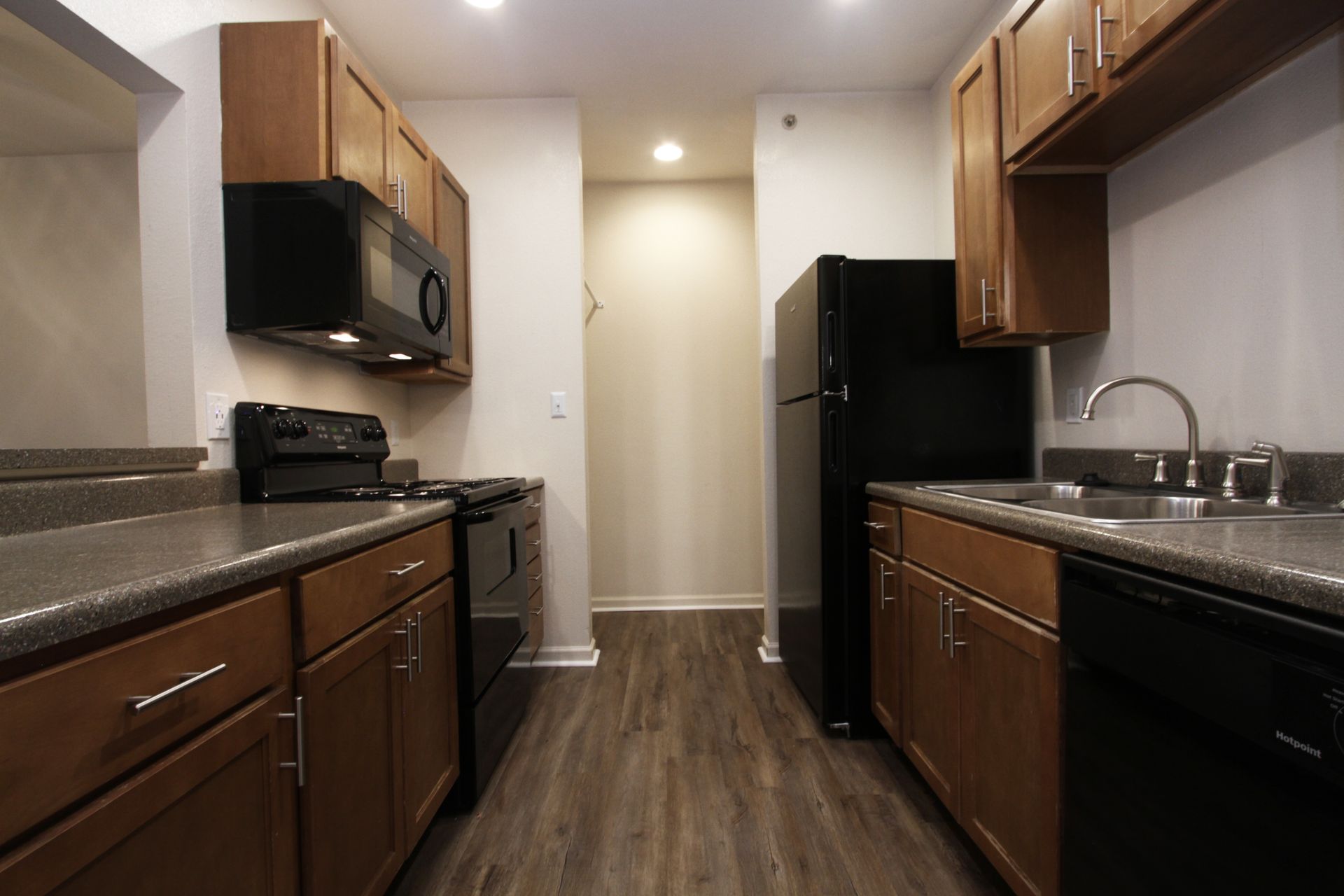 A kitchen with wooden cabinets and a black refrigerator
