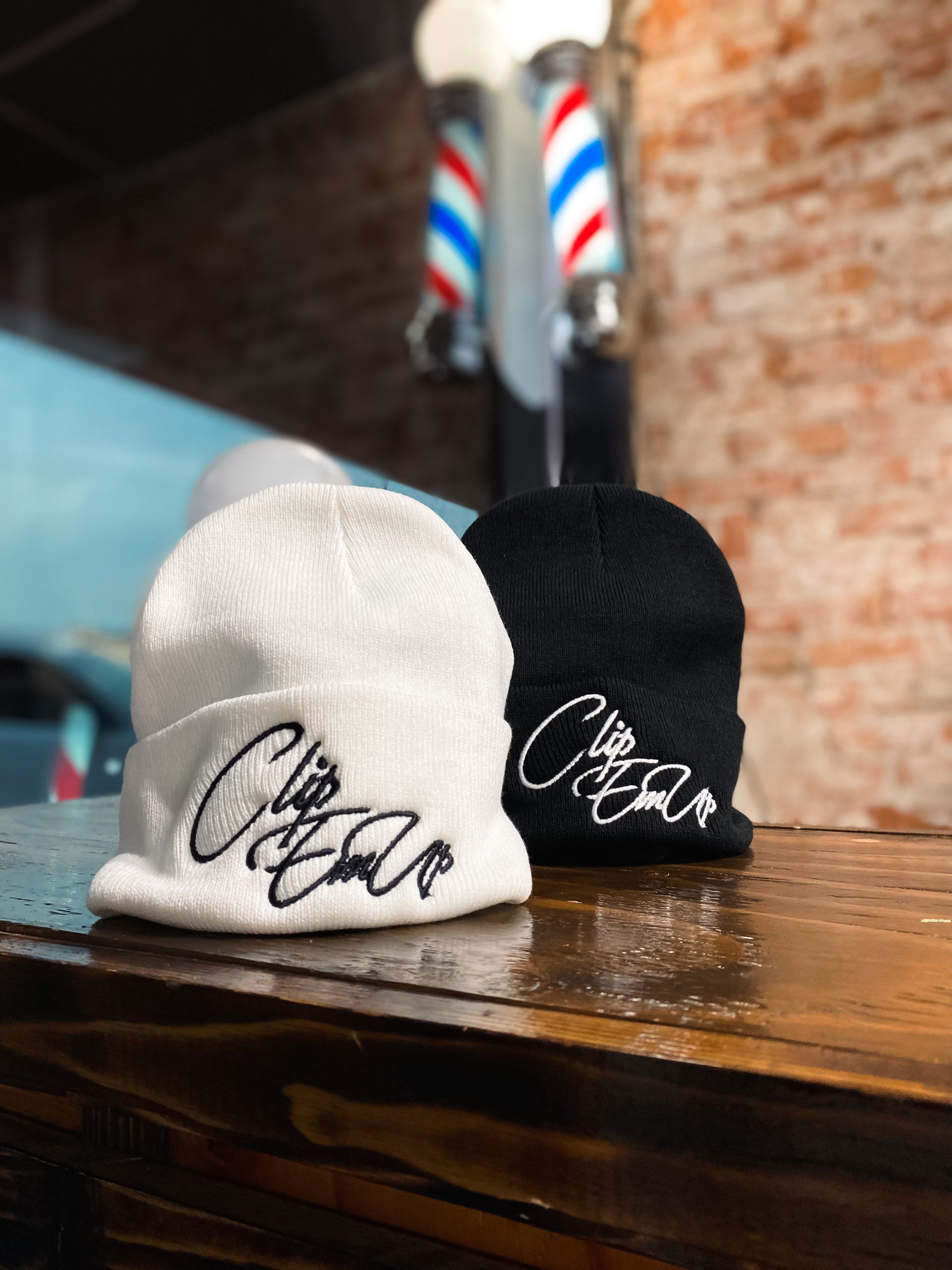 White and black beanies with Clip Em' Up staple logo
