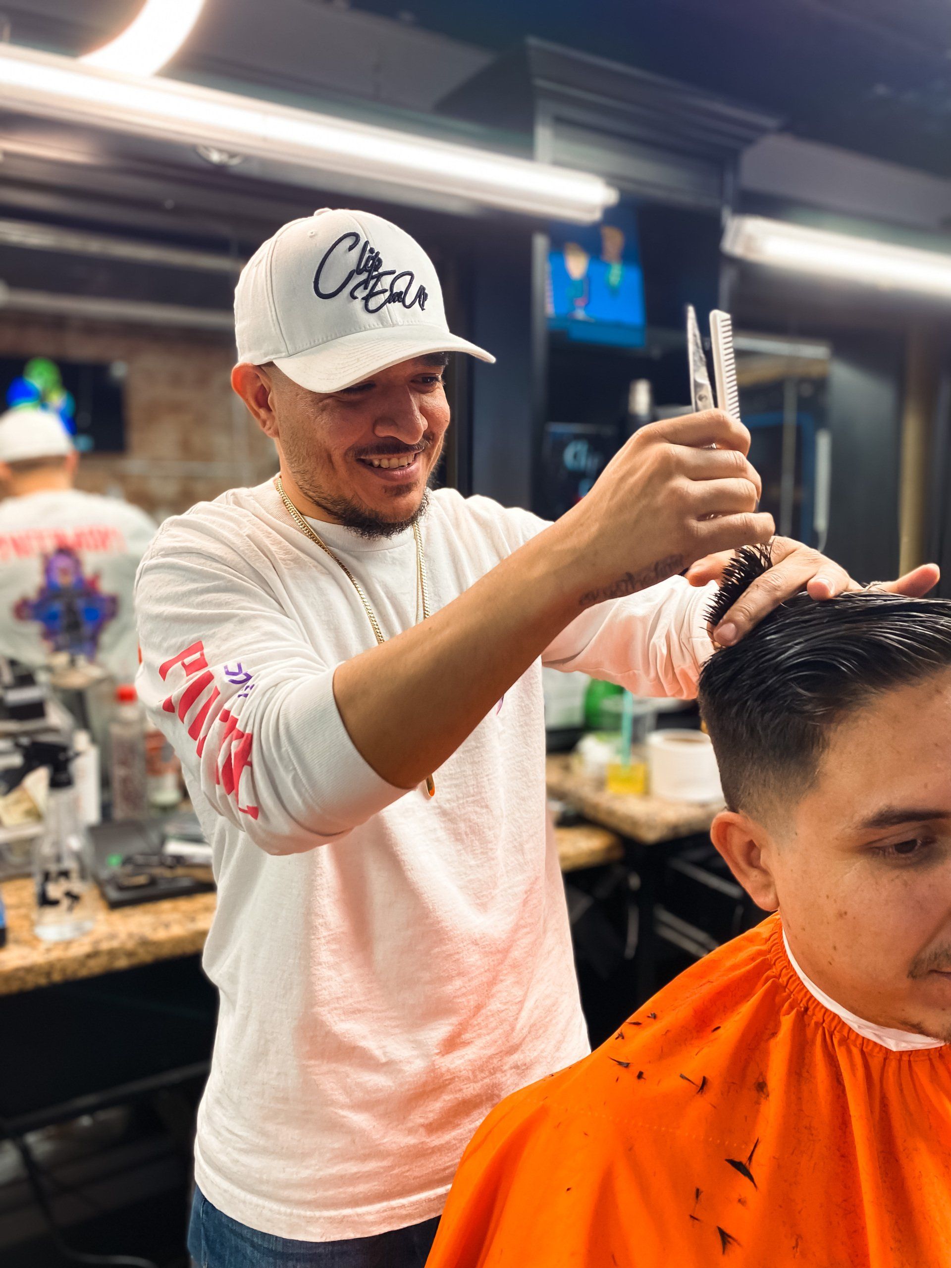 Sergio barber at Clip Em' Up cutting hair