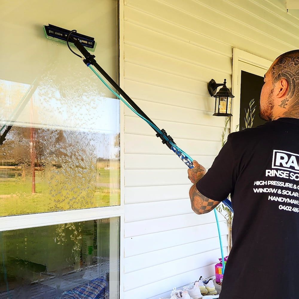 Man Cleaning Window With Long Brush — Rapid Rinse Solutions in Katunga, VIC