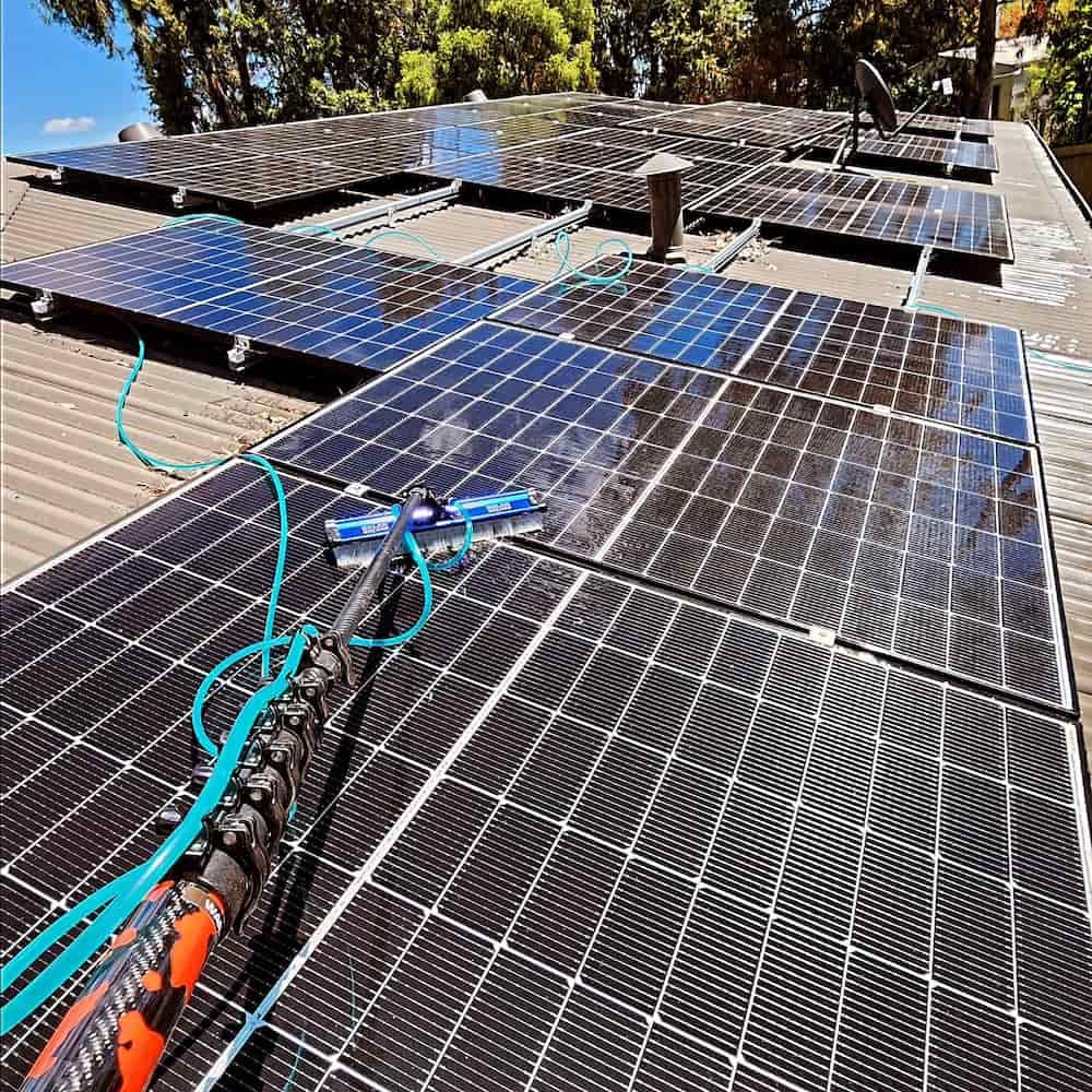 Solar Panels Being Cleaned on a Roof With a Long Handled Brush — Rapid Rinse Solutions in Katunga, VIC