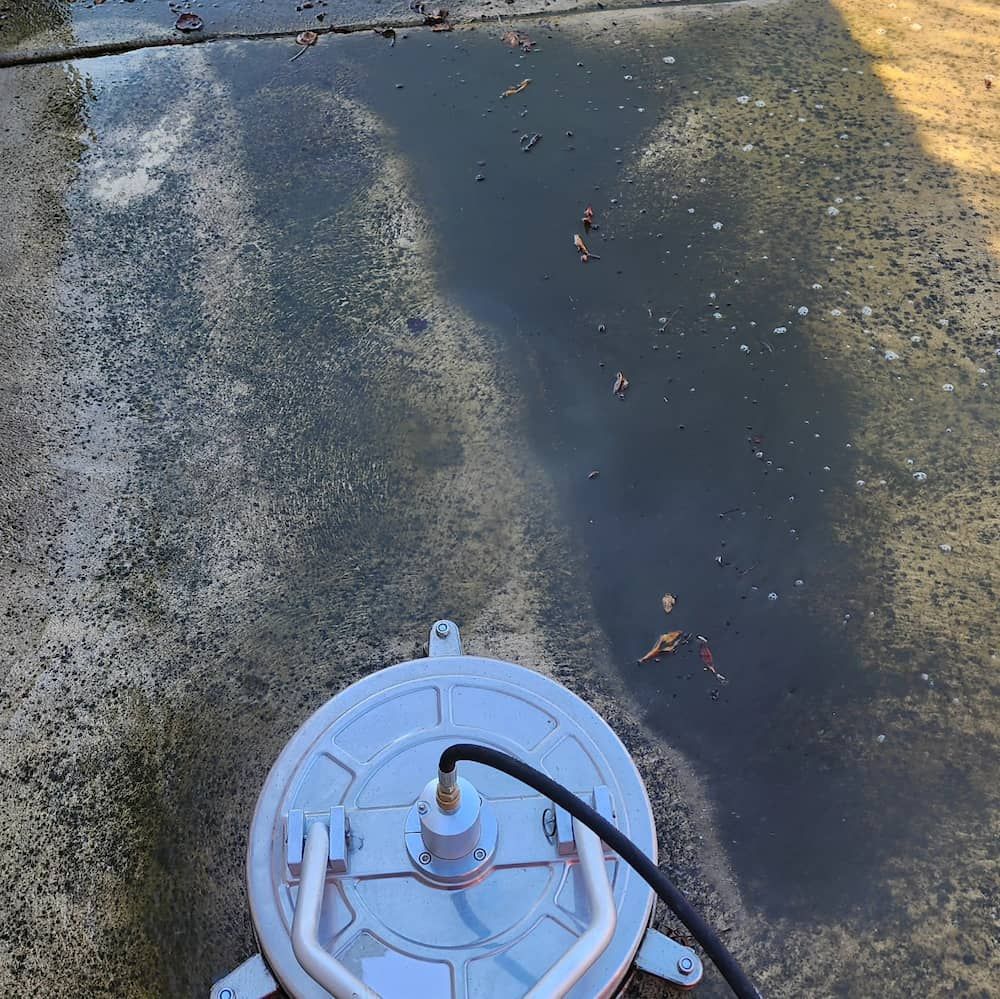 A Round Power Washer Cleaning a Wet Concrete Surface — Rapid Rinse Solutions in Katunga, VIC